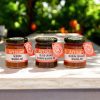 The Artisan Kitchen Selection of three Negroni marmalades citrus trees in the background