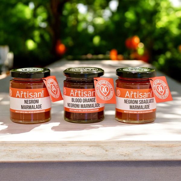 The Artisan Kitchen Selection of three Negroni marmalades citrus trees in the background