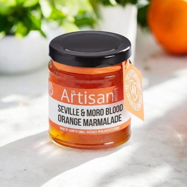 a jar of seville orange and blood range marmalade on a sunny countertop